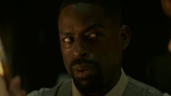 Movie still from “Hotel Artemis” (2018), directed by Drew Pearce – A person wearing a suit and tie; Close Up shot, Low angle