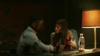 Movie still from “Hotel Artemis” (2018), directed by Drew Pearce – A man and a woman sitting at a table; Medium shot, Over the shoulder angle