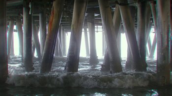 Movie still from “Hotel Artemis” (2018), directed by Drew Pearce – A view from under a pier of the ocean and waves; Extreme Wide shot, Low angle