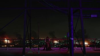Movie still from “Hotel Artemis” (2018), directed by Drew Pearce – A woman sitting on top of a pole at night; Extreme Wide shot, High angle