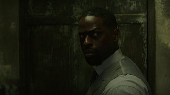 Movie still from “Hotel Artemis” (2018), directed by Drew Pearce – A man in a white shirt and a gray tie; Close Up shot, Over the shoulder angle