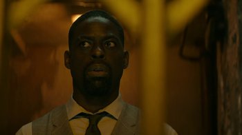 Movie still from “Hotel Artemis” (2018), directed by Drew Pearce – A man in a suit and tie looking up at the ceiling; Close Up shot, Low angle