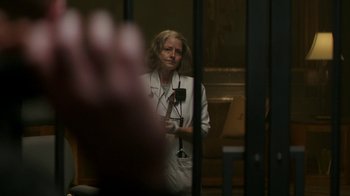 Movie still from “Hotel Artemis” (2018), directed by Drew Pearce – A woman wearing a white lab coat standing in front of a window; Close Up shot, Over the shoulder angle