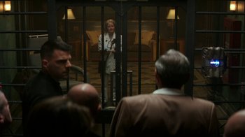 Movie still from “Hotel Artemis” (2018), directed by Drew Pearce – A person standing in a room with people standing around; Wide shot, Over the shoulder angle