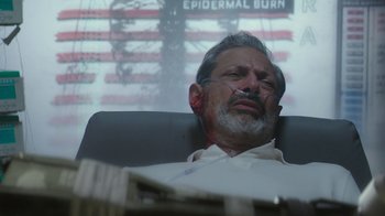 Movie still from “Hotel Artemis” (2018), directed by Drew Pearce – An older man sitting in front of an american flag; Close Up shot, Low angle