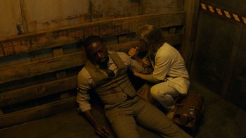Movie still from “Hotel Artemis” (2018), directed by Drew Pearce – A man and a woman sitting on the ground; Medium shot, Overhead angle