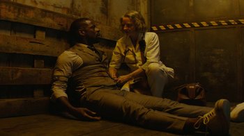 Movie still from “Hotel Artemis” (2018), directed by Drew Pearce – A man and a woman sitting on the ground; Medium shot, High angle
