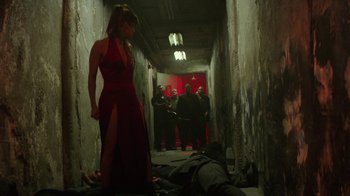 Movie still from “Hotel Artemis” (2018), directed by Drew Pearce – A woman in a red dress standing next to a dead body; Wide shot, High angle