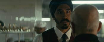 Movie still from “Hotel Mumbai” (2018), directed by Anthony Maras – A person with a beard wearing a turban; Close Up shot, Over the shoulder angle