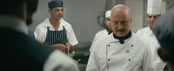 Movie still from “Hotel Mumbai” (2018), directed by Anthony Maras – A group of men standing around in a kitchen; Close Up shot, Over the shoulder angle