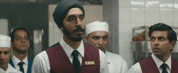 Movie still from “Hotel Mumbai” (2018), directed by Anthony Maras – A man in a turban and a man in a chef's outfit; Close Up shot, Over the shoulder angle