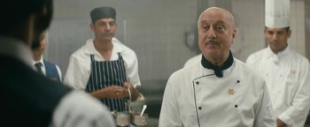 Movie still from “Hotel Mumbai” (2018), directed by Anthony Maras – Two men in a kitchen wearing chef's clothes; Medium shot, Over the shoulder angle