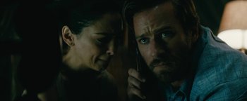 Movie still from “Hotel Mumbai” (2018), directed by Anthony Maras – A man and a woman looking at each other while holding a cell phone to their ear; Close Up shot, Low angle