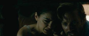 Movie still from “Hotel Mumbai” (2018), directed by Anthony Maras – A young woman looking down at a young man; Close Up shot, High angle
