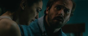 Movie still from “Hotel Mumbai” (2018), directed by Anthony Maras – A man and a woman looking at something on a computer screen; Close Up shot, Over the shoulder angle