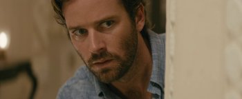 Movie still from “Hotel Mumbai” (2018), directed by Anthony Maras – A person with a beard looking at the camera; Close Up shot, Over the shoulder angle