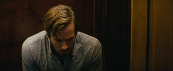 Movie still from “Hotel Mumbai” (2018), directed by Anthony Maras – A person sitting down; Close Up shot, Over the shoulder angle