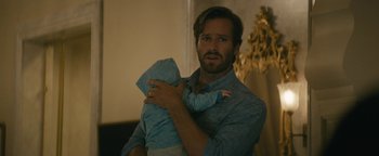 Movie still from “Hotel Mumbai” (2018), directed by Anthony Maras – A man holding a baby in his arms; Close Up shot, Over the shoulder angle