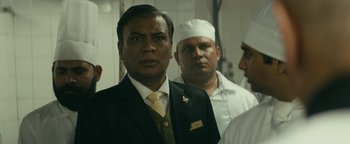 Movie still from “Hotel Mumbai” (2018), directed by Anthony Maras – A group of men standing next to each other in a room; Close Up shot, Over the shoulder angle