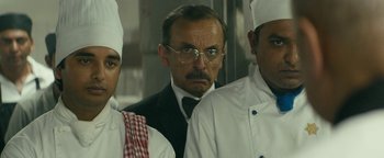 Movie still from “Hotel Mumbai” (2018), directed by Anthony Maras – A group of men standing next to each other in a kitchen; Close Up shot, Over the shoulder angle