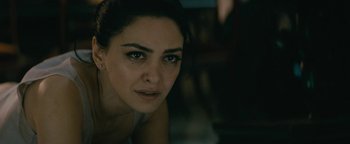 Movie still from “Hotel Mumbai” (2018), directed by Anthony Maras – A woman's face in a dark room; Close Up shot, Over the shoulder angle