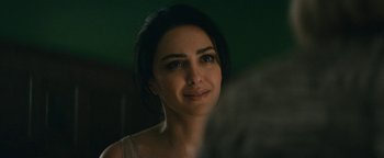 Movie still from “Hotel Mumbai” (2018), directed by Anthony Maras – A beautiful woman with dark brown hair and blue eyes looking at the camera; Close Up shot, Over the shoulder angle