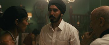 Movie still from “Hotel Mumbai” (2018), directed by Anthony Maras – A man wearing a turban and a white shirt; Close Up shot, Over the shoulder angle
