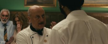 Movie still from “Hotel Mumbai” (2018), directed by Anthony Maras – A man in a chef's outfit talking to another man; Close Up shot, Over the shoulder angle