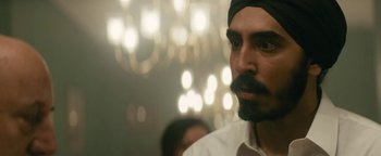 Movie still from “Hotel Mumbai” (2018), directed by Anthony Maras – A man with a beard and a black turban; Close Up shot, Over the shoulder angle