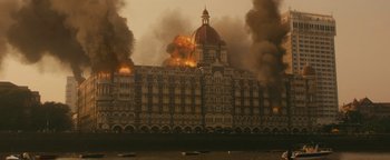 Movie still from “Hotel Mumbai” (2018), directed by Anthony Maras – A building that has been set on fire; Extreme Wide shot, High angle