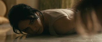 Movie still from “Hotel Mumbai” (2018), directed by Anthony Maras – A woman laying on the ground looking at the camera; Close Up shot, High angle