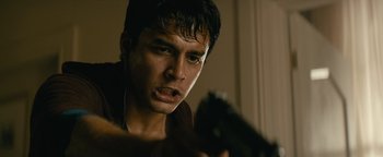 Movie still from “Hotel Mumbai” (2018), directed by Anthony Maras – A young man holding a gun in his hand; Close Up shot, Low angle