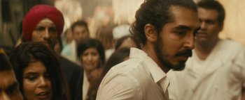 Movie still from “Hotel Mumbai” (2018), directed by Anthony Maras – A group of people standing in a room; Close Up shot, Over the shoulder angle