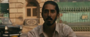 Movie still from “Hotel Mumbai” (2018), directed by Anthony Maras – A person wearing a shirt; Close Up shot, Over the shoulder angle
