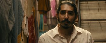 Movie still from “Hotel Mumbai” (2018), directed by Anthony Maras – A person wearing a white shirt; Close Up shot, Over the shoulder angle