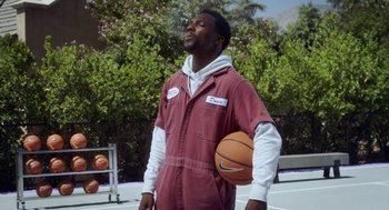 Movie still from “House Party” (2023), directed by Calmatic – A man holding a basketball in his hands; Medium shot, Low angle