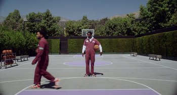 Movie still from “House Party” (2023), directed by Calmatic – Two men are playing basketball on a purple court; Wide shot, Over the shoulder angle