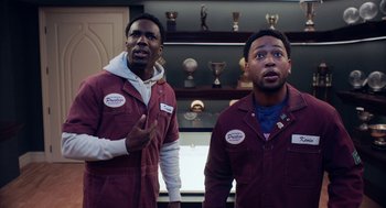 Movie still from “House Party” (2023), directed by Calmatic – A couple of men standing next to each other in a room; Medium shot, Low angle