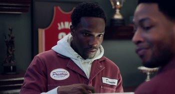 Movie still from “House Party” (2023), directed by Calmatic – A man in a red jacket is looking at a piece of paper; Close Up shot, Over the shoulder angle
