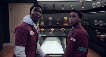 Movie still from “House Party” (2023), directed by Calmatic – A couple of men standing next to each other in a room; Medium shot, High angle