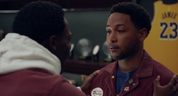 Movie still from “House Party” (2023), directed by Calmatic – Two men are standing in a room and one of them has his hand on the other's shoulder; Close Up shot, Over the shoulder angle