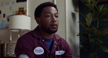 Movie still from “House Party” (2023), directed by Calmatic – A man in a maroon jacket is looking at the camera; Close Up shot, Over the shoulder angle