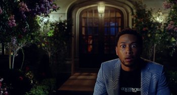 Movie still from “House Party” (2023), directed by Calmatic – A man standing in front of a building at night; Medium shot, Low angle