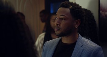 Movie still from “House Party” (2023), directed by Calmatic – A man in a blue jacket looking to his left; Close Up shot, Over the shoulder angle
