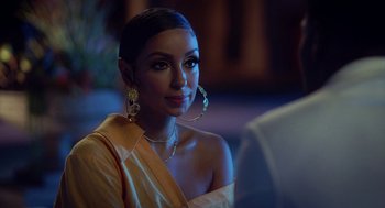 Movie still from “House Party” (2023), directed by Calmatic – A woman in a yellow dress and gold jewelry; Close Up shot, Over the shoulder angle