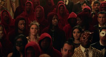 Movie still from “House Party” (2023), directed by Calmatic – A group of people wearing red hoods in front of a crowd; Medium shot, High angle