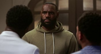 Movie still from “House Party” (2023), directed by Calmatic – A person wearing a hooded sweatshirt; Close Up shot, Over the shoulder angle