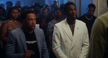 Movie still from “House Party” (2023), directed by Calmatic – A group of people standing in front of a wall; Medium shot, Over the shoulder angle