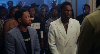 Movie still from “House Party” (2023), directed by Calmatic – A group of men standing next to each other in a room; Medium shot, Over the shoulder angle