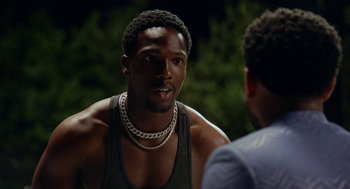 Movie still from “House Party” (2023), directed by Calmatic – A man wearing a necklace talking to another man; Close Up shot, Over the shoulder angle
